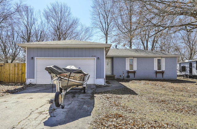 ranch-style house featuring a garage, brick siding, driveway, and fence