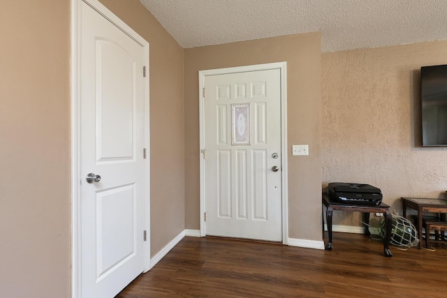 entryway featuring dark wood-style flooring, a textured ceiling, and baseboards