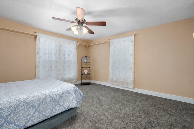 carpeted bedroom featuring ceiling fan, a textured ceiling, and baseboards