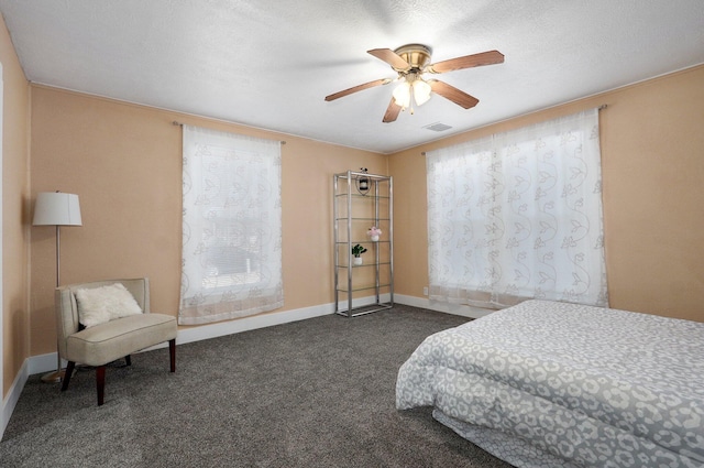 bedroom with baseboards, visible vents, a ceiling fan, a textured ceiling, and carpet flooring