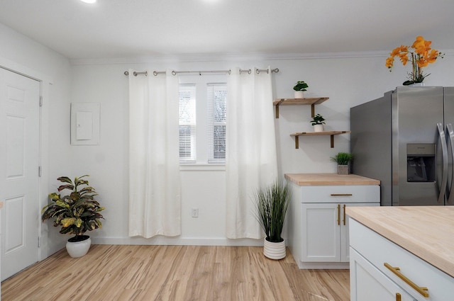 interior space featuring light wood finished floors, open shelves, butcher block countertops, and stainless steel refrigerator with ice dispenser