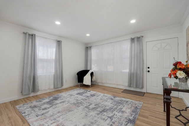 interior space with ornamental molding, light wood-type flooring, recessed lighting, and baseboards