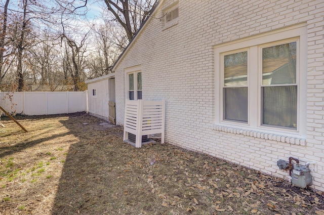 exterior space featuring fence and brick siding