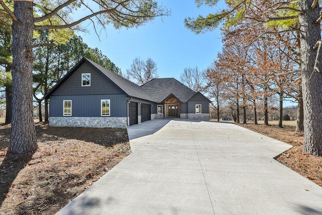 view of front facade with stone siding, concrete driveway, and an attached garage