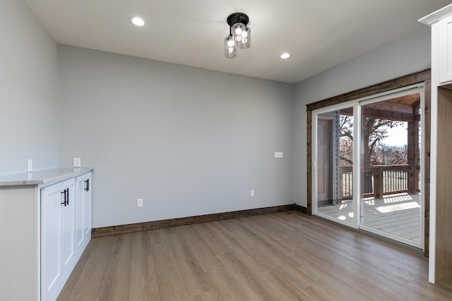 unfurnished room featuring recessed lighting, light wood-style flooring, and baseboards