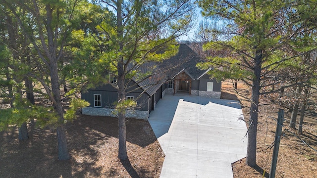 view of front of house featuring stone siding and driveway