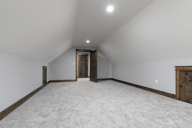 additional living space featuring lofted ceiling, carpet, baseboards, and recessed lighting