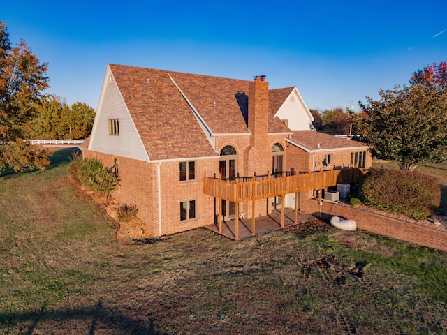 back of house featuring brick siding, a yard, a chimney, a patio area, and a deck