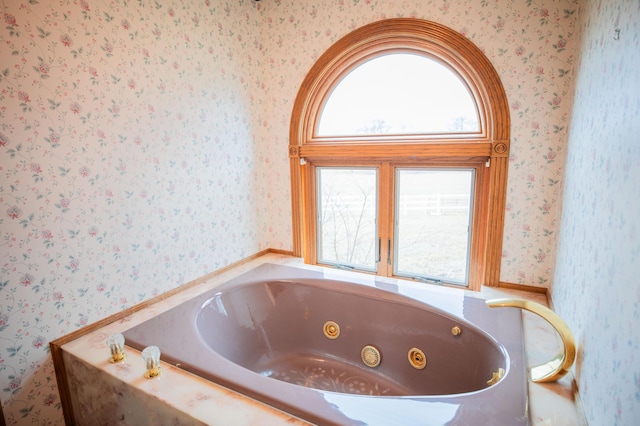 full bathroom featuring wallpapered walls and a tub with jets