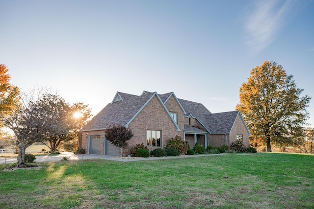 view of front of home with a garage, brick siding, and a front yard