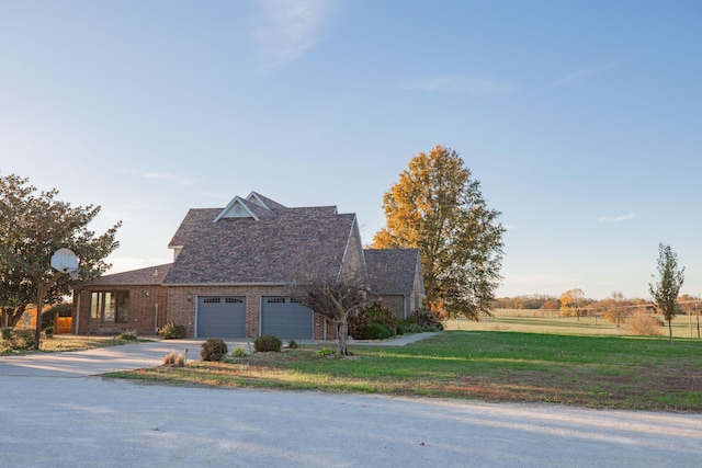 traditional-style house featuring a garage, concrete driveway, brick siding, and a front yard