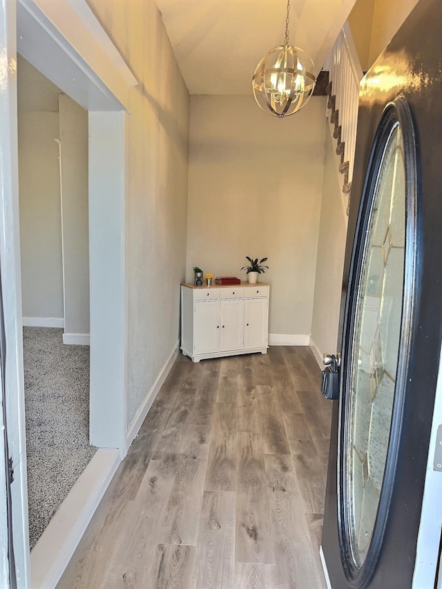 interior space featuring a notable chandelier, baseboards, and wood finished floors