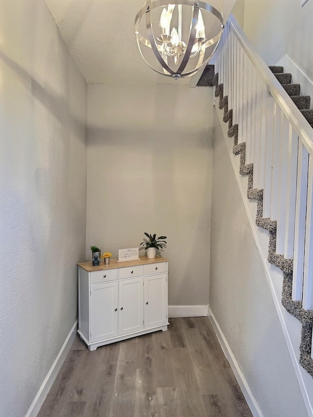 interior space featuring an inviting chandelier, baseboards, and wood finished floors