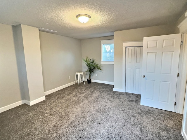 unfurnished bedroom featuring a textured ceiling, a closet, carpet flooring, and baseboards