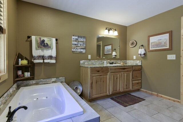 bathroom with tile patterned flooring, baseboards, vanity, and a tub with jets