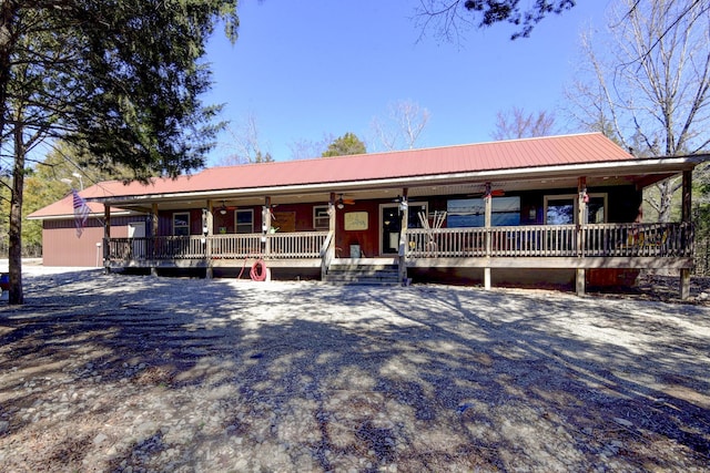 ranch-style home featuring covered porch and metal roof