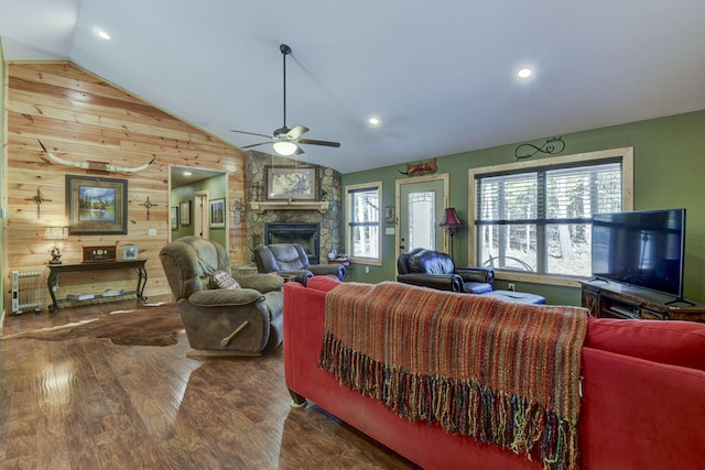 living area with lofted ceiling, wooden walls, a fireplace, and wood finished floors