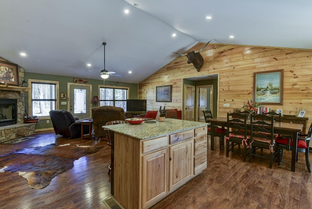 kitchen featuring open floor plan, dark wood-type flooring, vaulted ceiling, and a fireplace