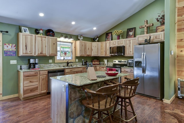 kitchen with dark wood finished floors, light brown cabinetry, appliances with stainless steel finishes, vaulted ceiling, and a sink