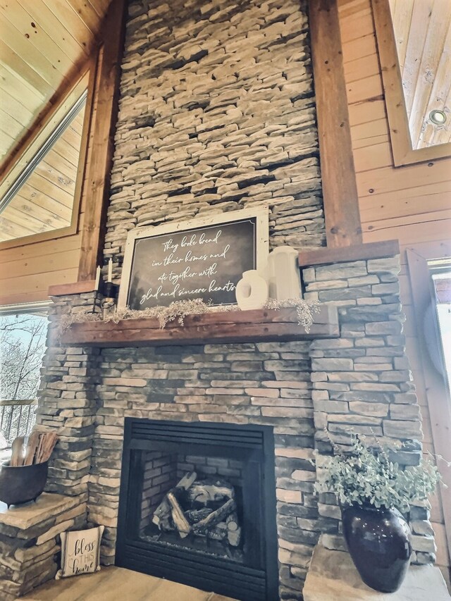 details with wooden walls and a stone fireplace