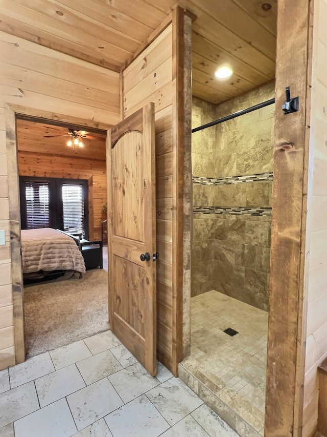 ensuite bathroom with wood walls, a tile shower, wood ceiling, and connected bathroom