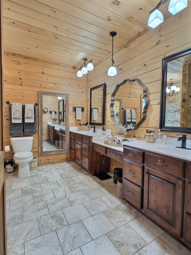 bathroom with toilet, wood ceiling, wooden walls, and vanity