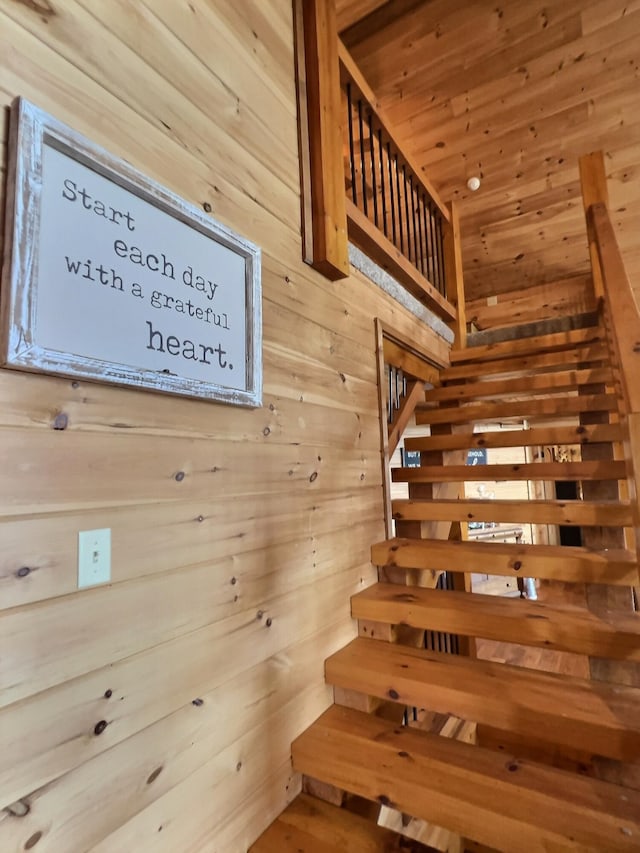 staircase featuring wooden walls, wood ceiling, and a sauna