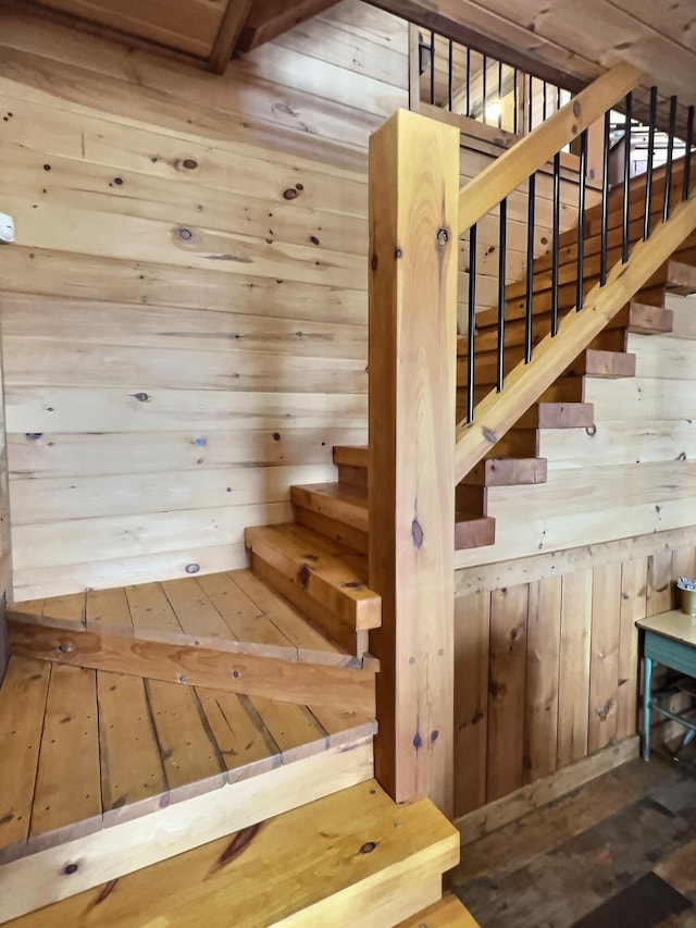 stairway featuring wooden walls and hardwood / wood-style floors