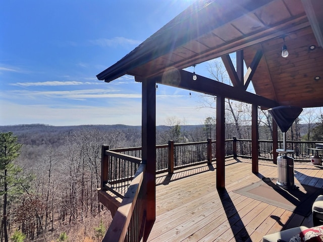 wooden terrace featuring a forest view