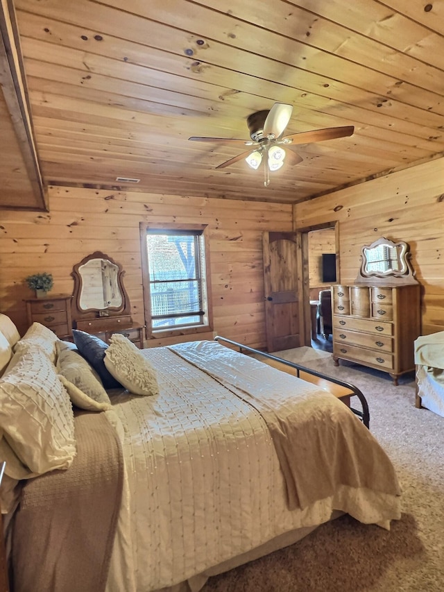 carpeted bedroom with wood ceiling, ceiling fan, and wooden walls