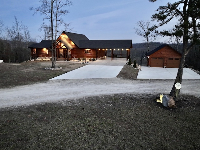 log-style house with a detached garage and an outbuilding