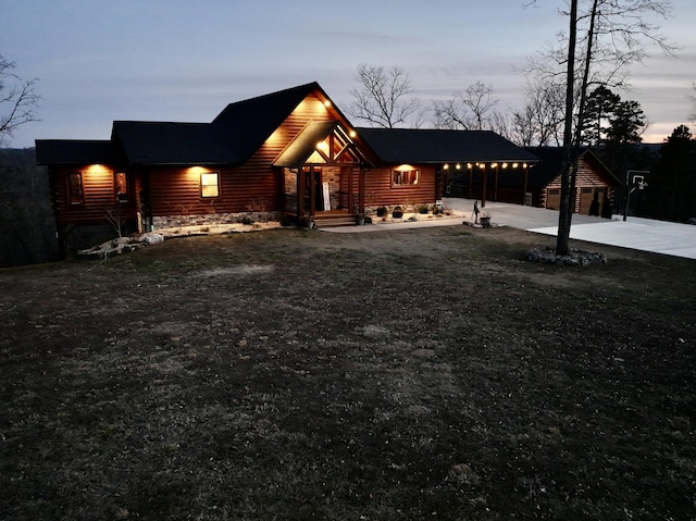 view of front facade with driveway and log veneer siding