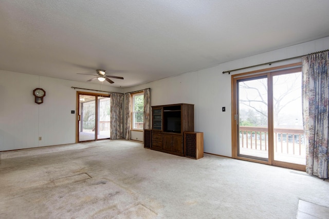 unfurnished living room with carpet, ceiling fan, and a textured ceiling