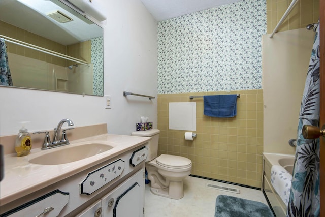 bathroom featuring tile walls, visible vents, toilet, vanity, and tile patterned flooring