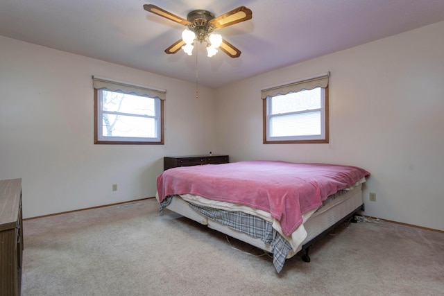 bedroom with a ceiling fan, carpet, multiple windows, and baseboards