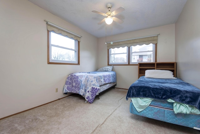 bedroom with a textured ceiling, ceiling fan, carpet flooring, and baseboards