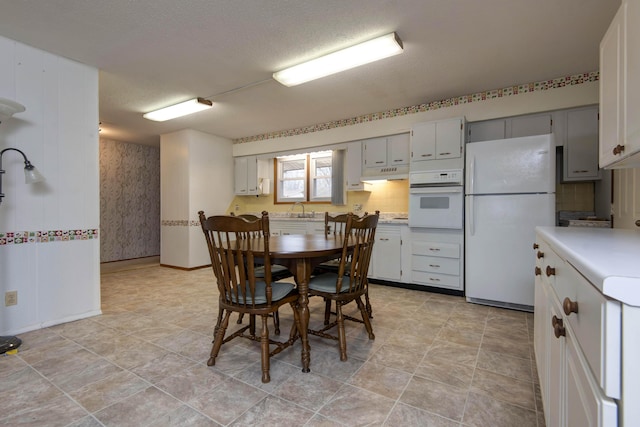 dining area featuring baseboards and a textured ceiling