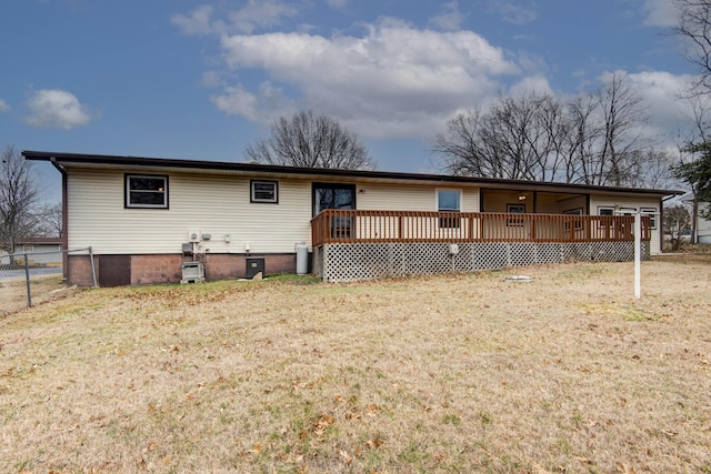 ranch-style house featuring fence, a wooden deck, and a front lawn