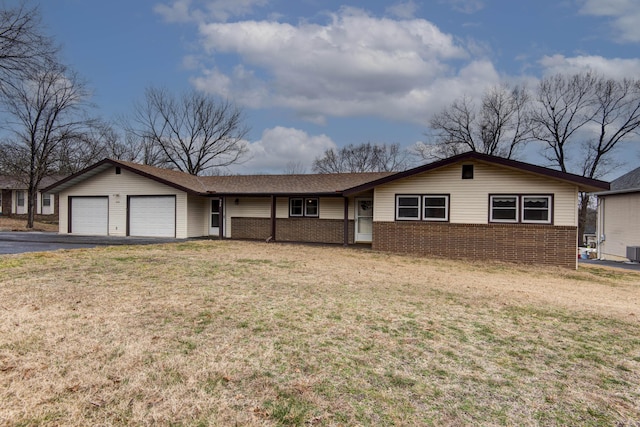 ranch-style home featuring aphalt driveway, brick siding, a front yard, central AC, and a garage