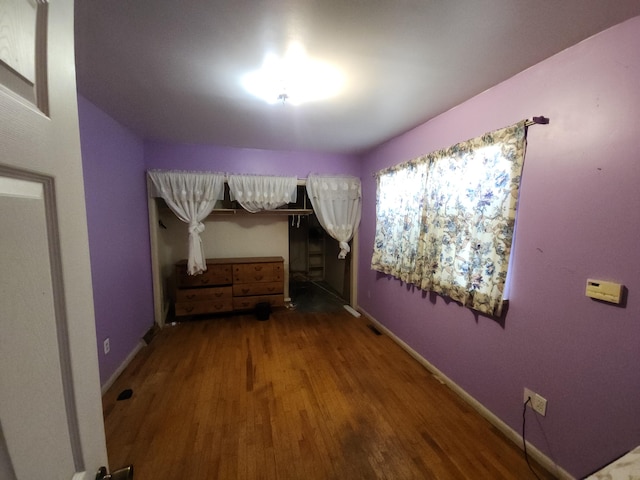 unfurnished bedroom with baseboards and wood finished floors