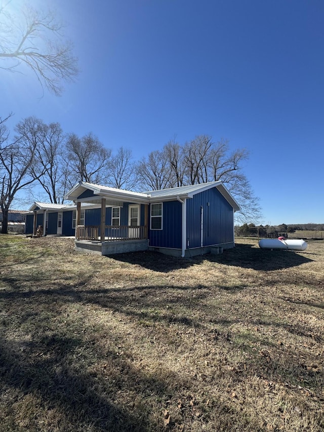 manufactured / mobile home featuring a front lawn, board and batten siding, and a porch