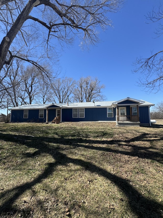 view of front of property with metal roof and a front yard