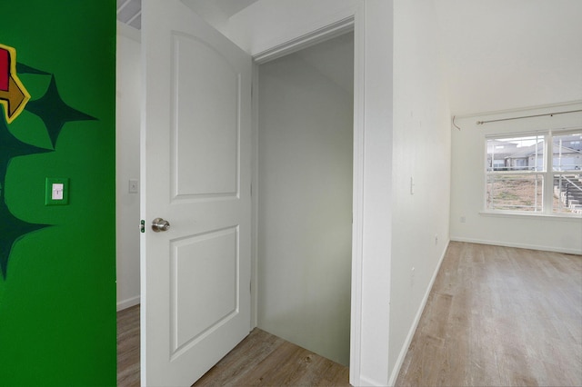 hallway featuring baseboards and wood finished floors