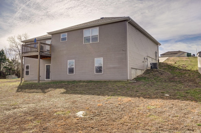 back of property featuring central AC unit and a lawn