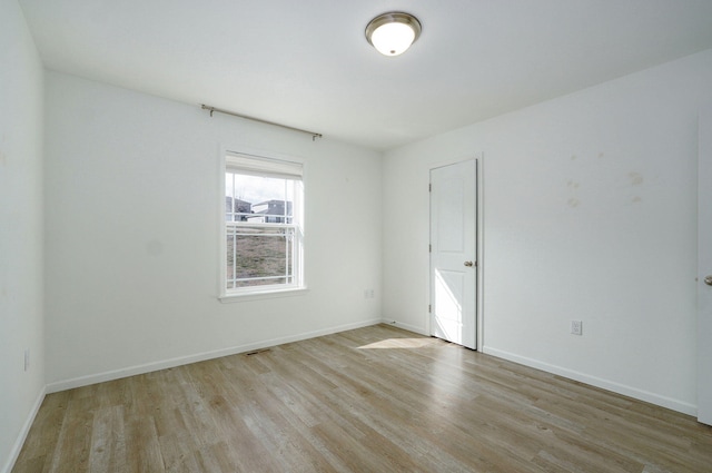 empty room with baseboards and wood finished floors