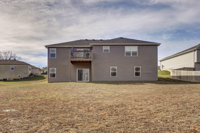 rear view of property with a lawn and a balcony