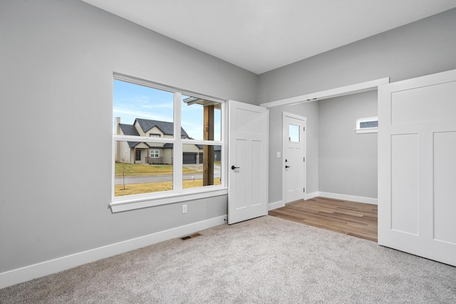 carpeted entryway with visible vents and baseboards