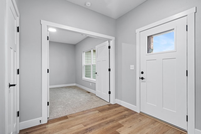 foyer entrance with light wood-style flooring and baseboards