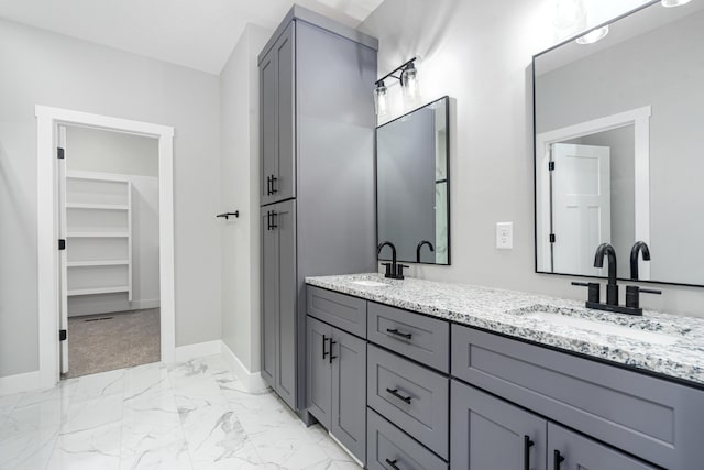 full bath with marble finish floor, a sink, and baseboards