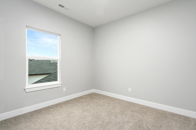 unfurnished room featuring light carpet, visible vents, and baseboards